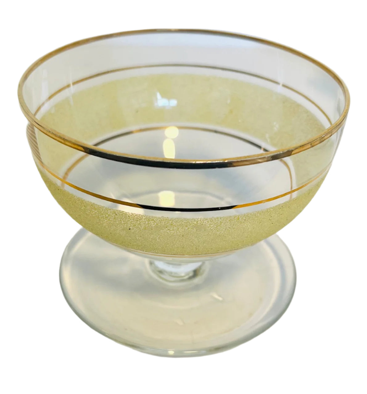 Clear glass with gold rim and interior on a white background